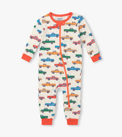 Cream baby sleeper with colorful truck print, orange trim, front zipper, and long sleeves