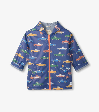 Blue zip-up kids raincoat with colorful pickup truck print and coral zipper, front view