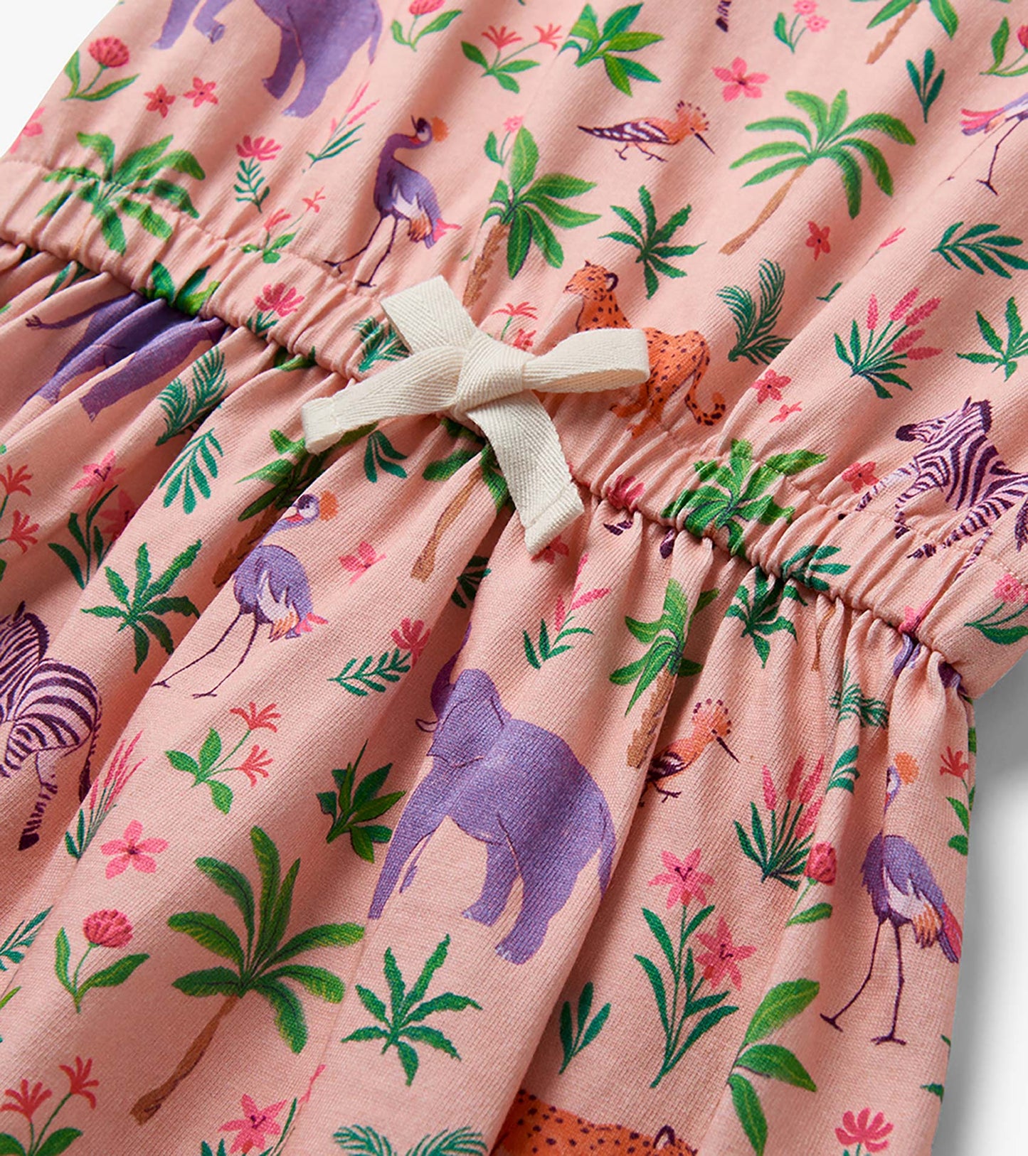 Pink toddler dress with safari animal and palm print, gathered waist, and cream tie detail