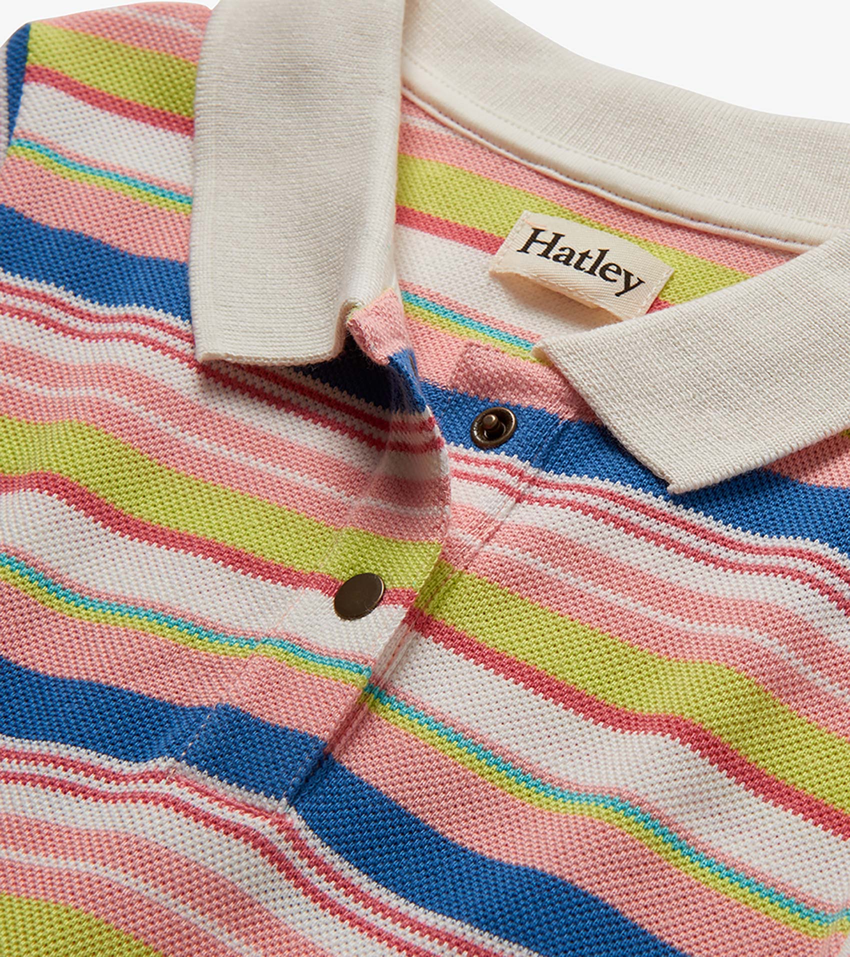 Close-up of a striped pique polo dress with cream collar and multicolor horizontal stripes, front buttons visible