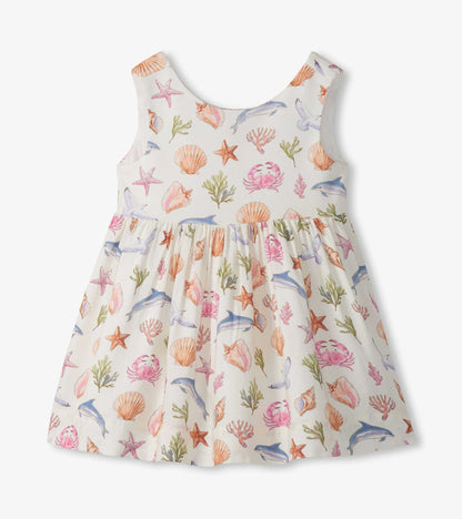 Sleeveless white toddler dress with pastel sea life print and gathered skirt, front view