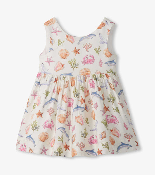 Sleeveless white toddler dress with pastel sea life print and gathered skirt, front view