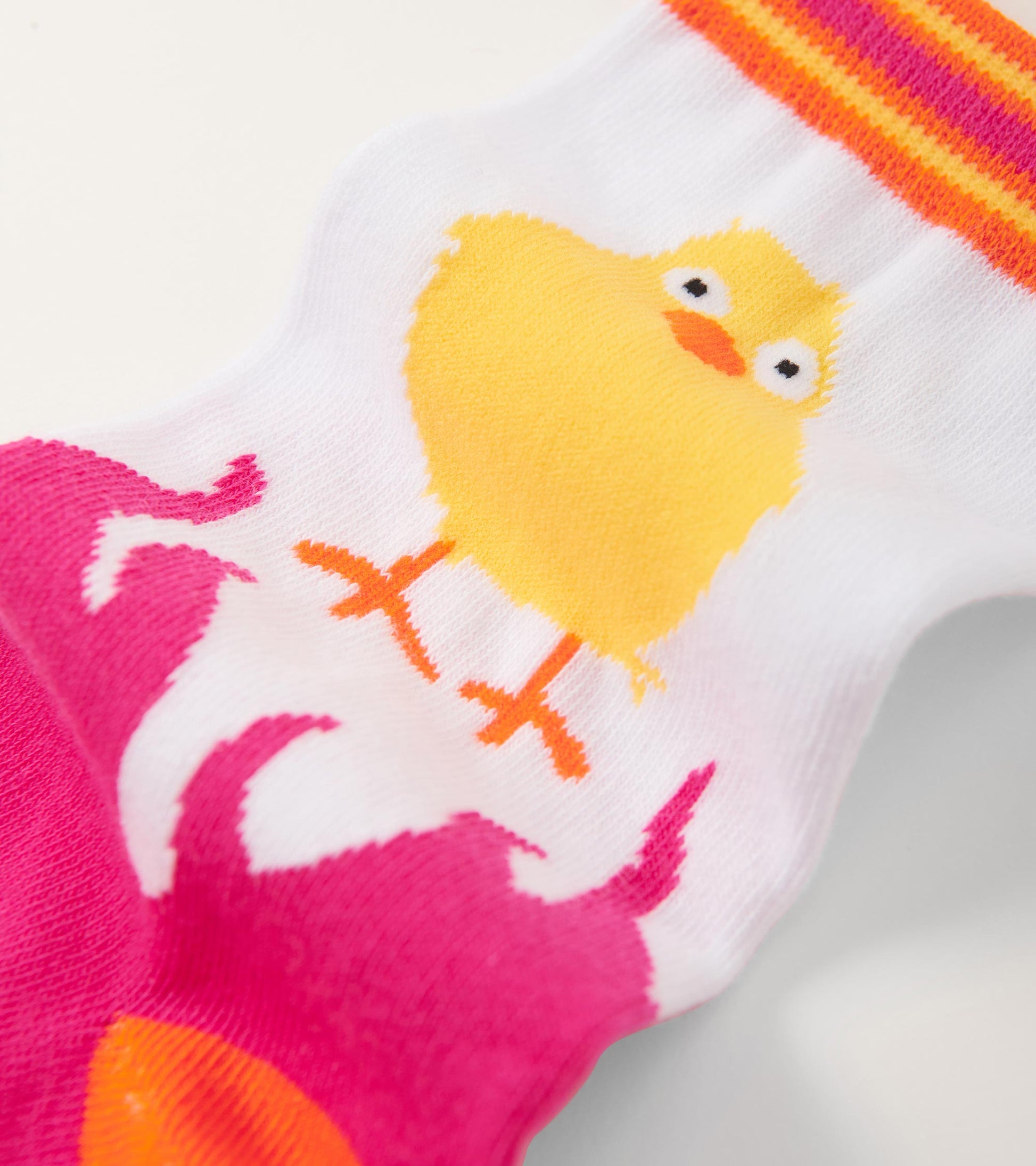 White crew socks featuring a yellow chick graphic and pink accents with striped top. One size fits all.
