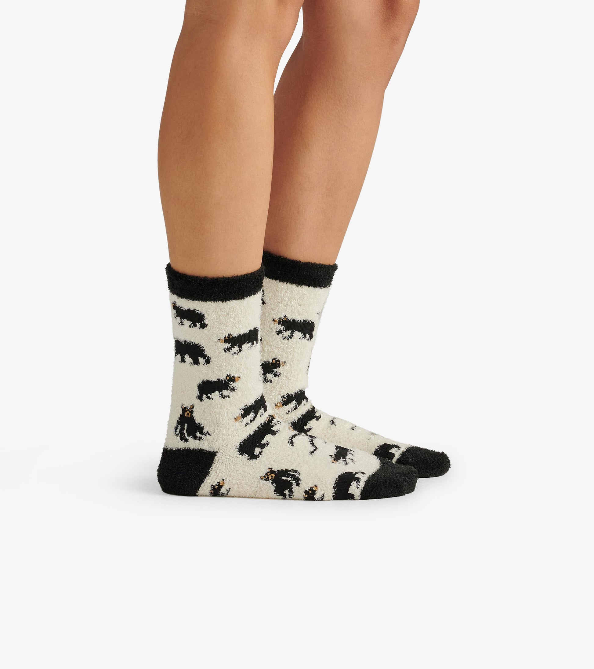 Cream crew socks featuring black bear patterns and black trim, designed for comfort and warmth.