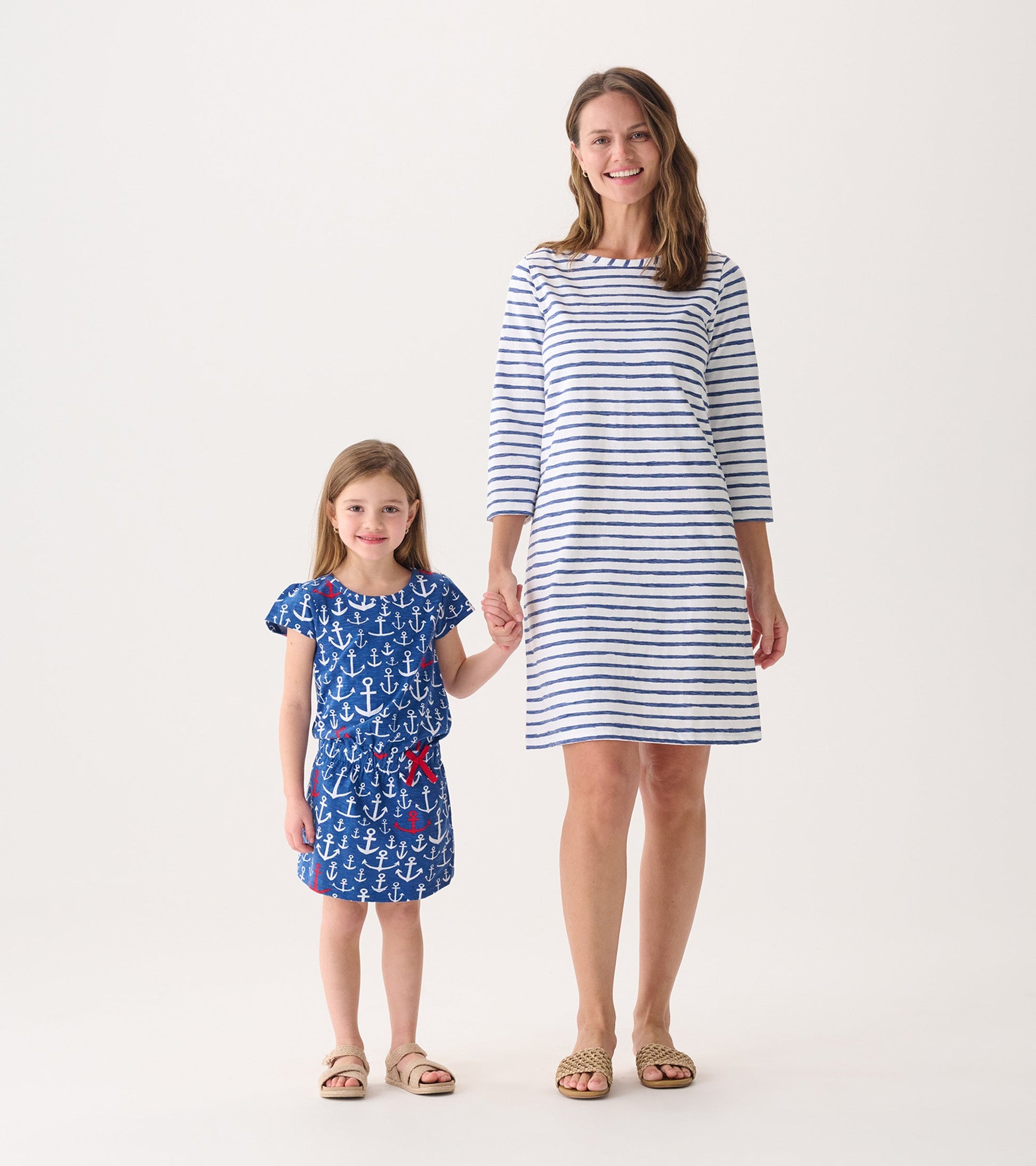 Women's 3/4 sleeve summer dress in white with blue watercolor stripes, paired with a girl in a blue anchor-patterned dress.