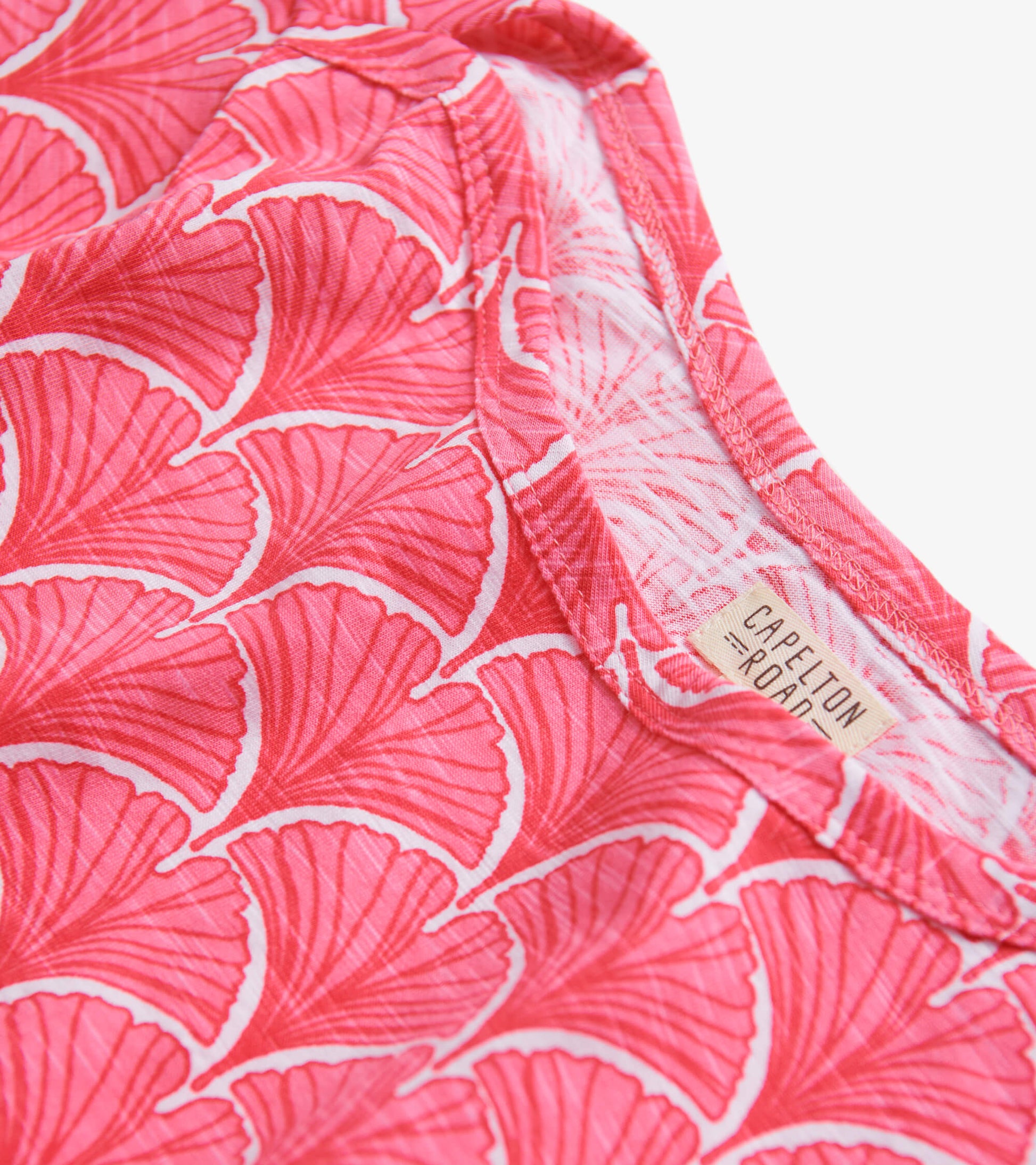 Coral summer dress featuring a fan pattern and 3/4 sleeves, showcasing a soft fabric and round neckline.