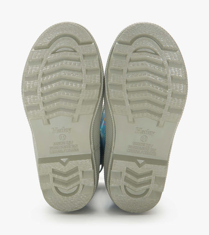 Pair of beige rubber rain boot soles with tread pattern, viewed from below