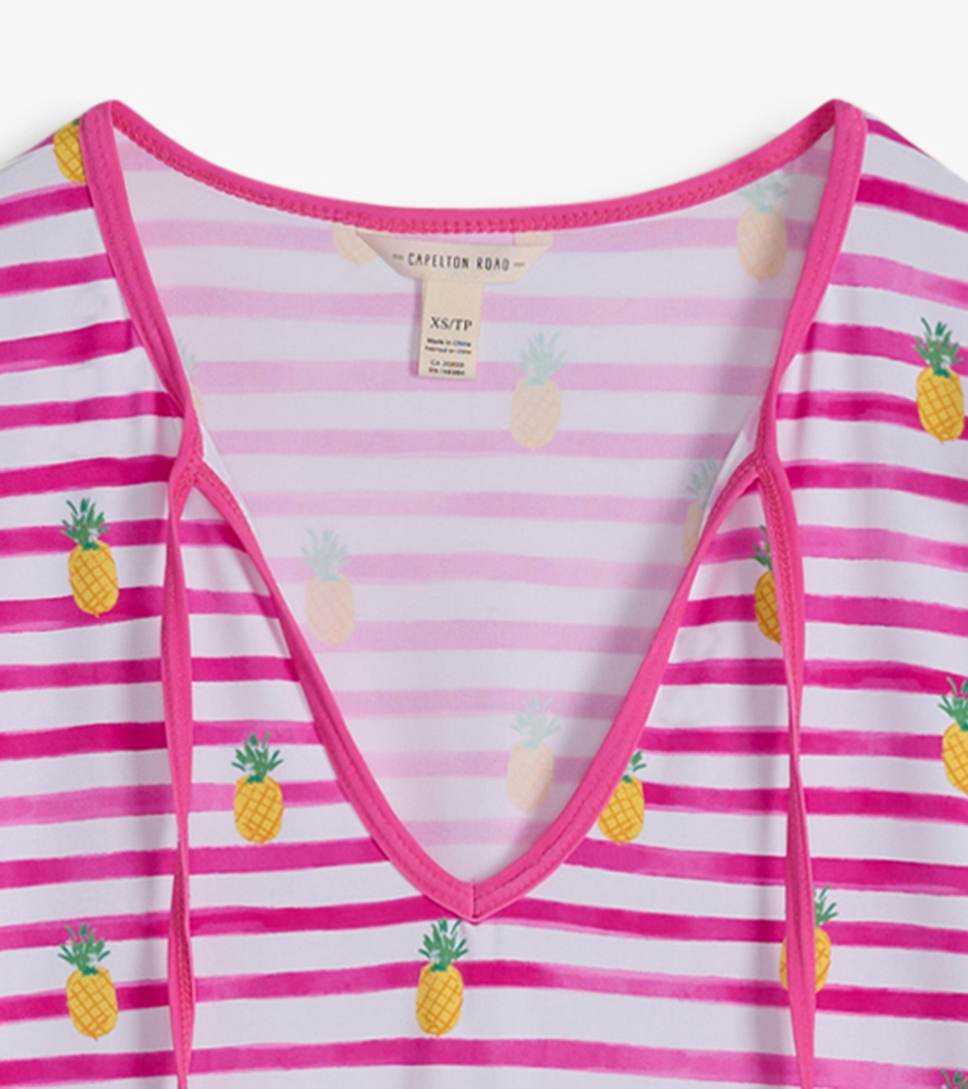 Pink and white striped beach dress featuring pineapple patterns and a V-neckline.