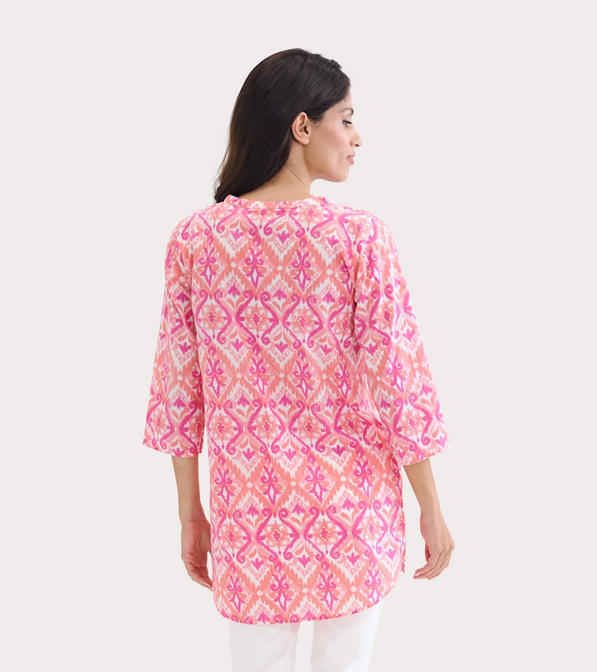 Back view of a pink and orange ikat tunic with three-quarter sleeves and a relaxed fit.