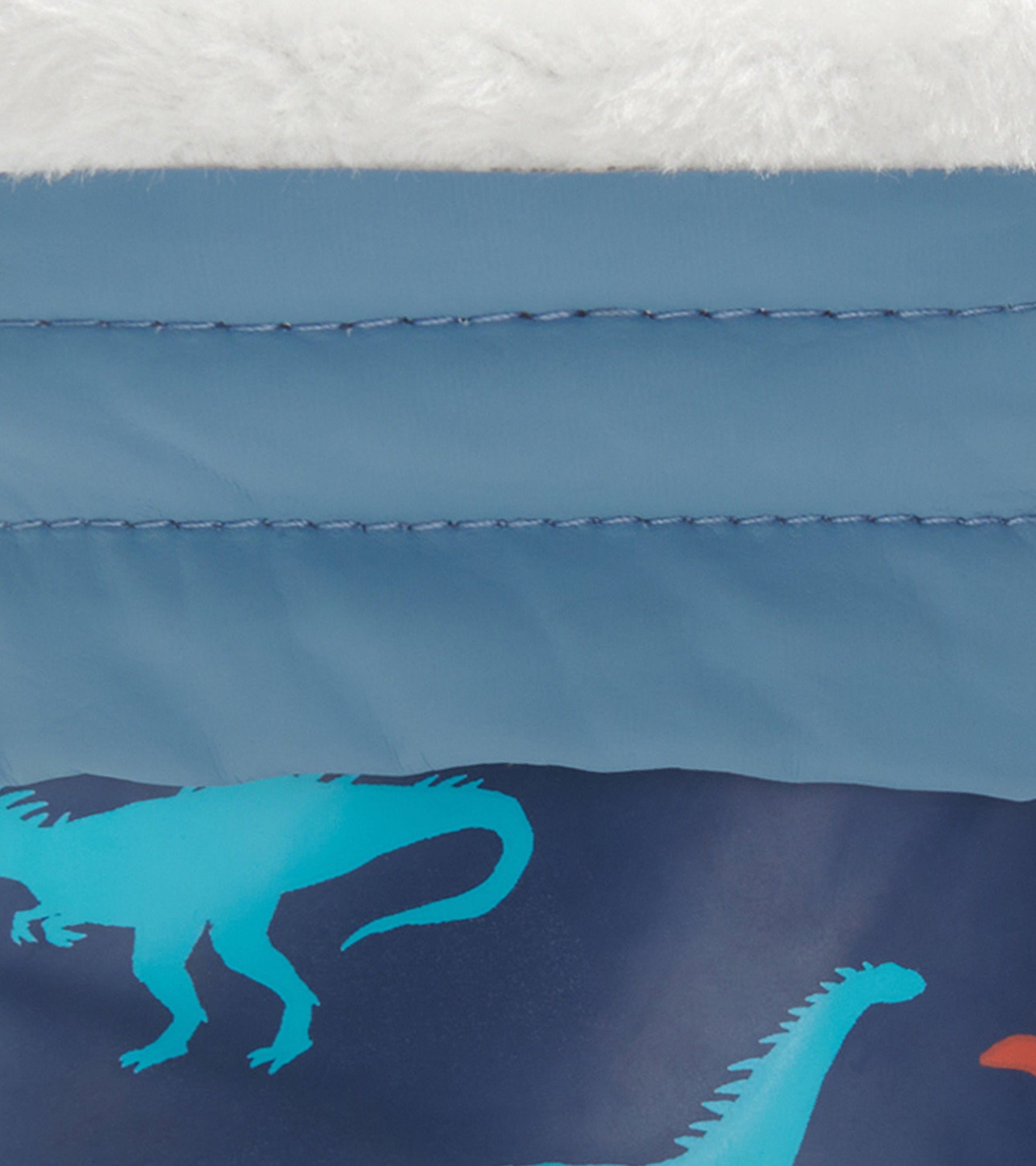 Blue kids' wellies with dinosaur silhouettes and a soft white Sherpa lining. Ideal for rainy outdoor play.