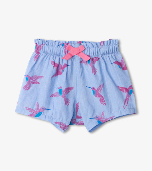 Light blue woven shorts featuring a colorful hummingbird print and a pink bow at the waistband. Suitable for babies.