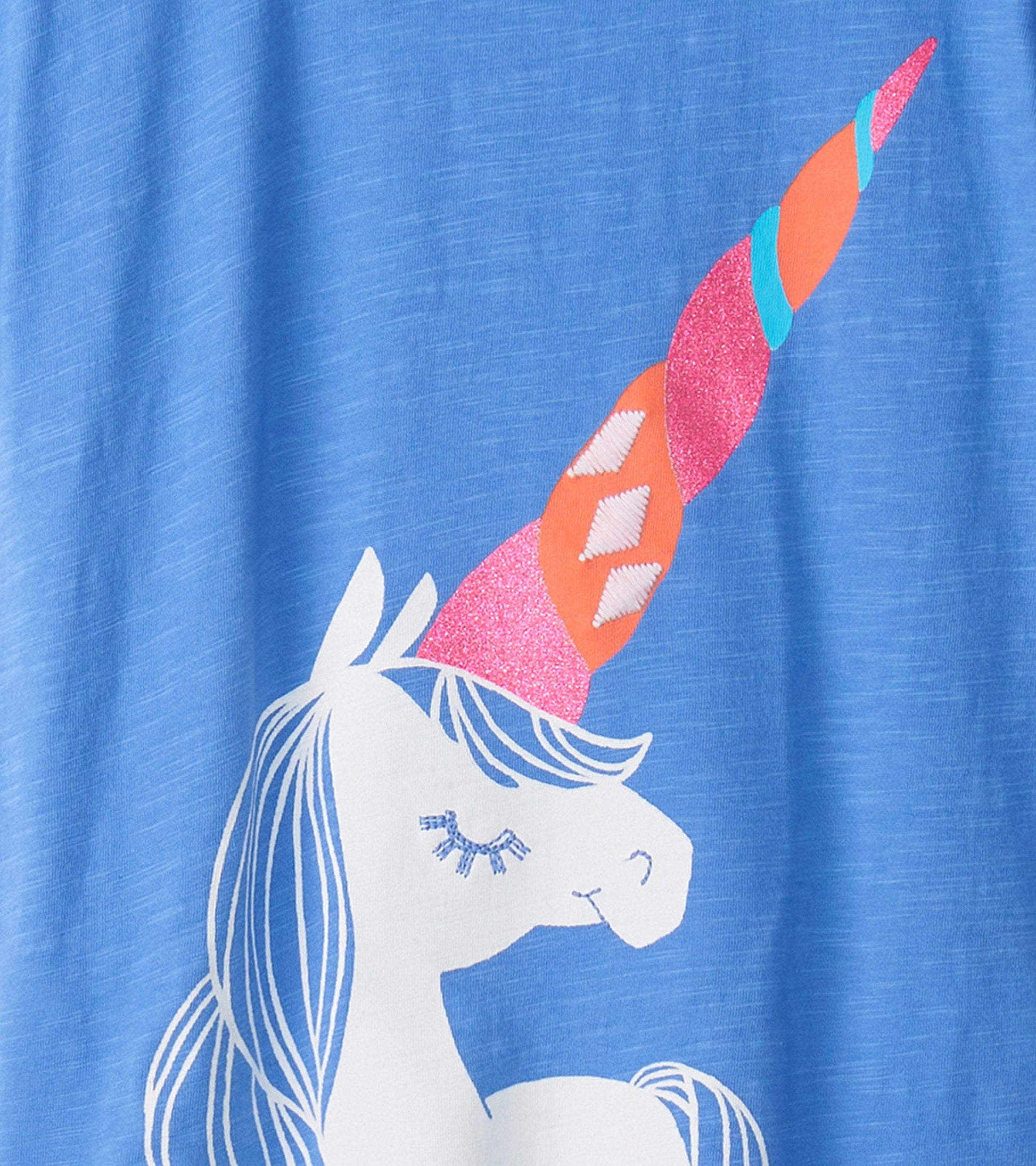 Light blue shirt featuring a white unicorn graphic with a colorful, glittery horn.