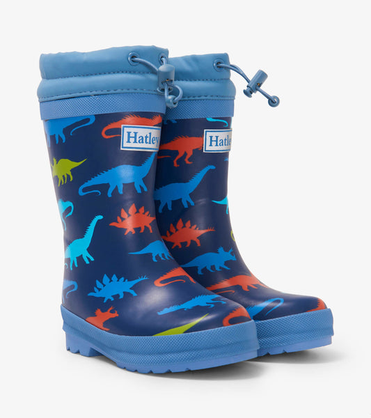 Navy blue kids' wellies featuring colorful dinosaur silhouettes and a sherpa lining, ideal for rainy days.
