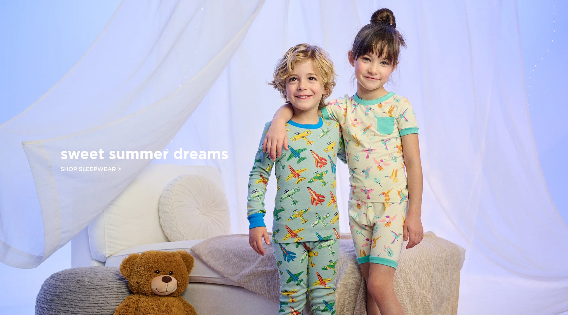Promotes kids' sleepwear. Showing two children standing on a bed in patterned pyjamas. With "sweet summer dreams" text.